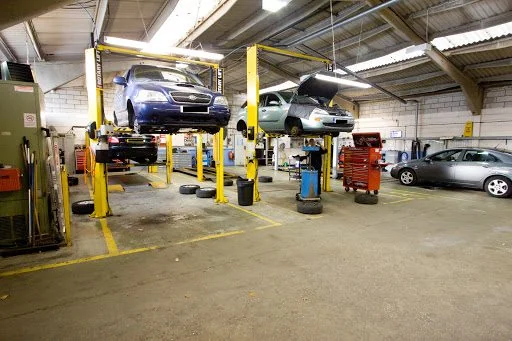 Two cars raised on the two-post ramps in the Tonbridge workshop